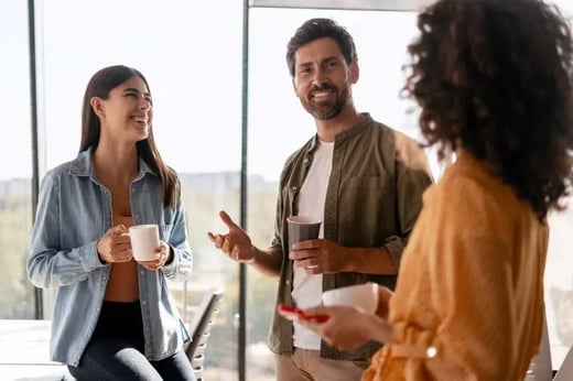 Three people standing talking in an office
