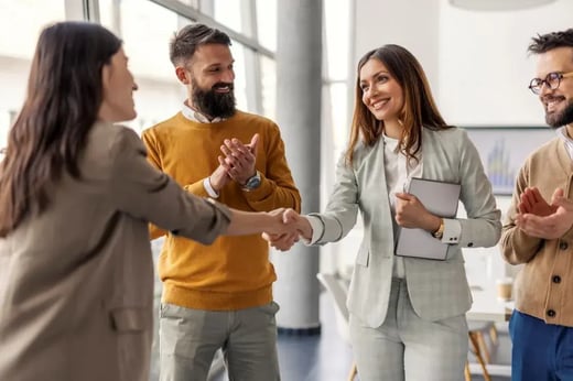 Coworkers shake hands in an office