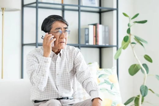 Worried older man talks on phone